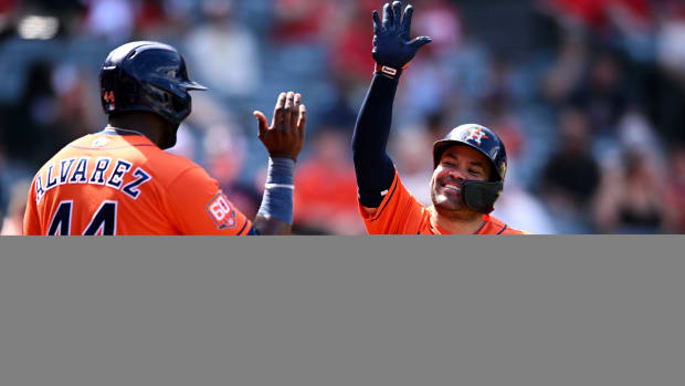 Jose Altuve and Yordan Álvarez high five at home plate.